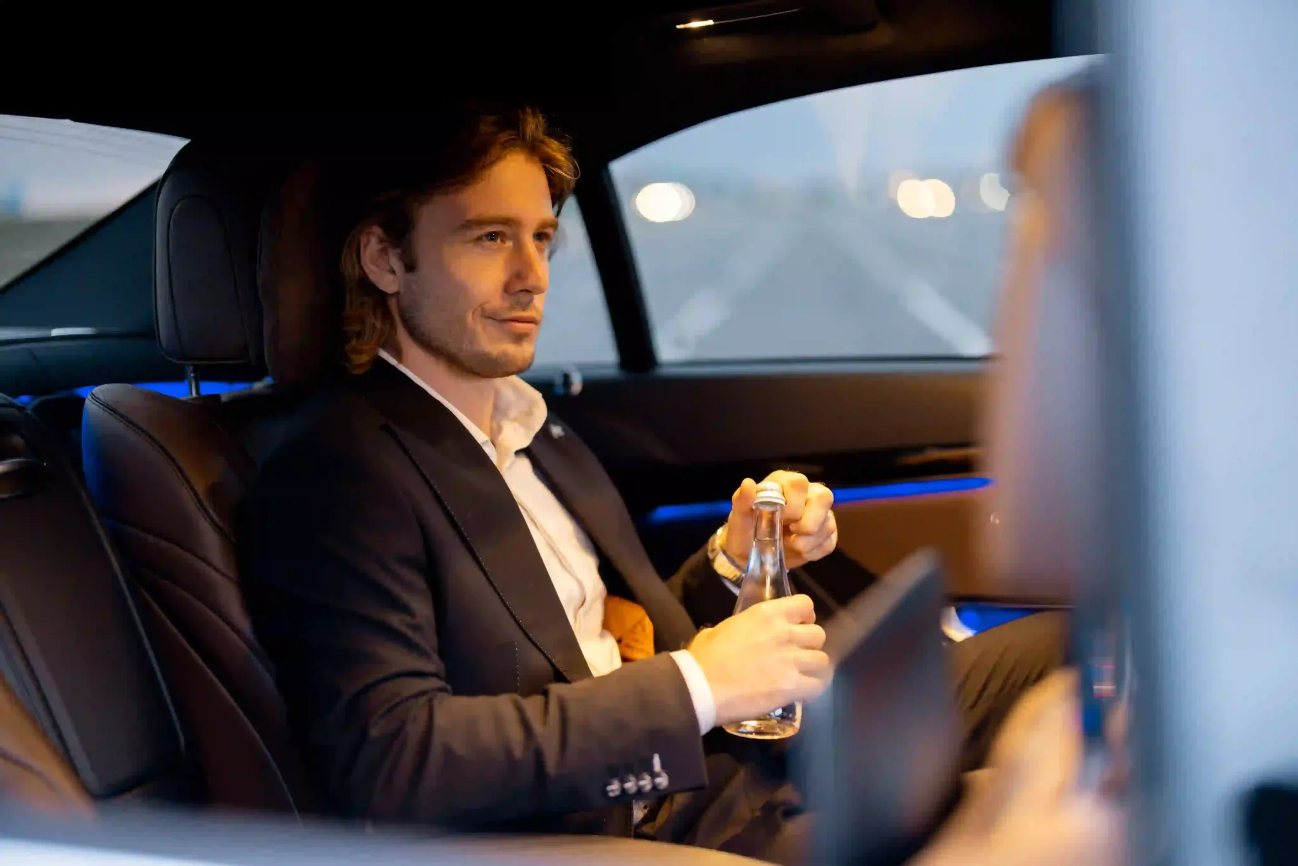 businessman-on-backseat-of-luxury-car-2023-11-27-05-33-48-utc-scaled.webp